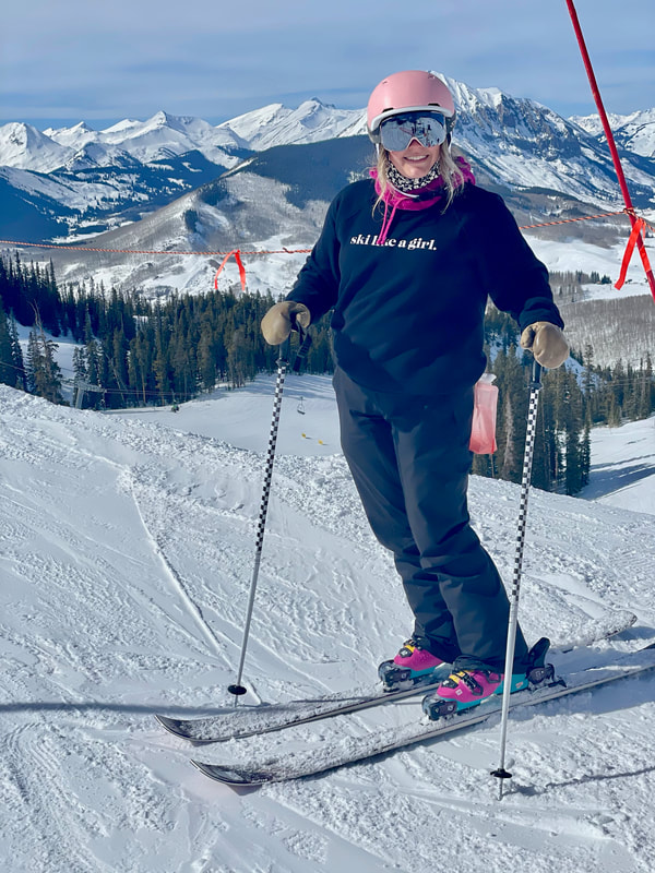 photo of a counselor posing on top of a ski hill