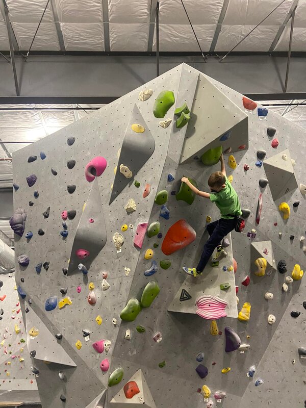 Camper climbing in an indoor rock climbing gym